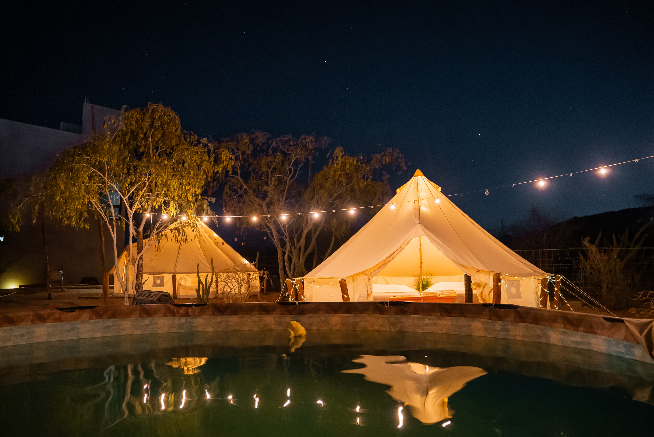 Glamping tents and pool at night in La Ventana