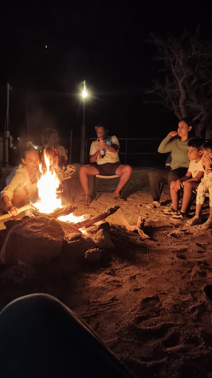 Guests gathering around a campfire at night
