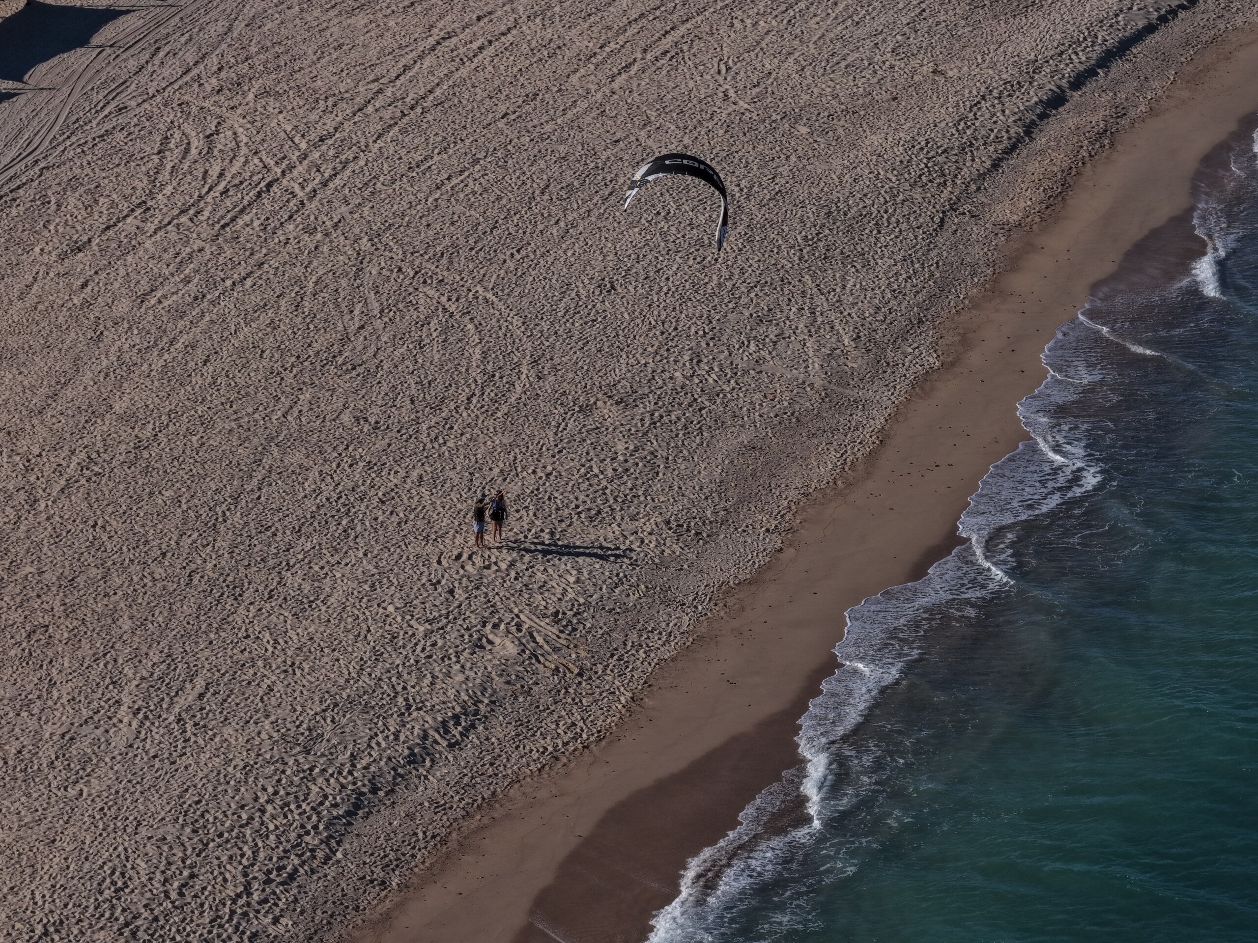 Aerial view of a kiteboarding lesson on the beach